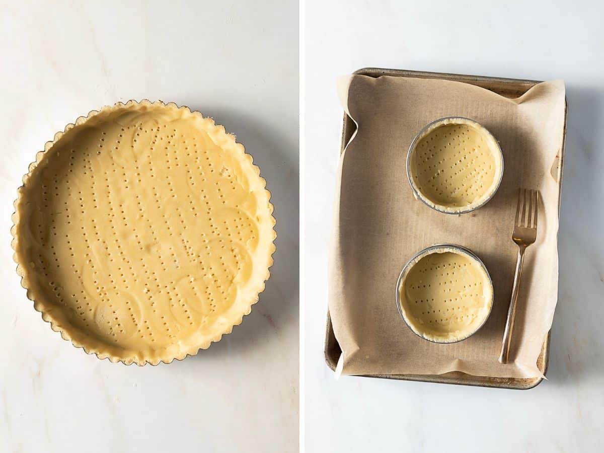 A large tart shell and two small tart shells made of Pâte Sucrée, each pierced with fork holes, are shown unbaked on a marble surface and a parchment-lined baking tray.
