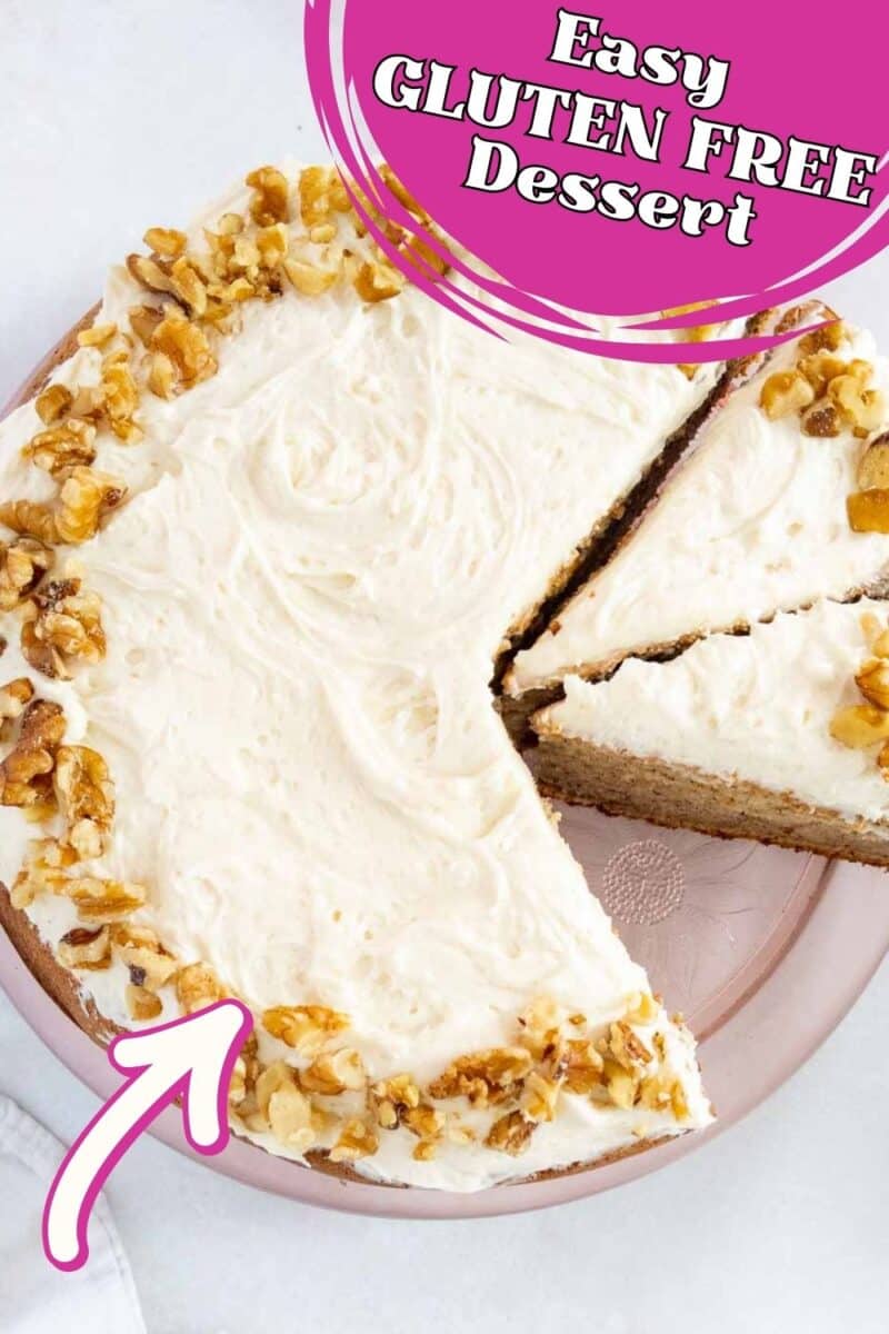 Round cake with white frosting and chopped walnuts on top, one slice removed