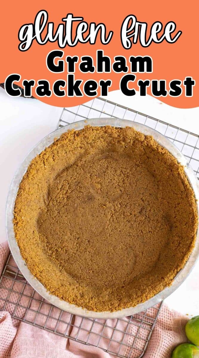 A Gluten-Free Graham Cracker Crust rests in a round pie dish on a cooling rack, with a pink towel partially visible beside it.