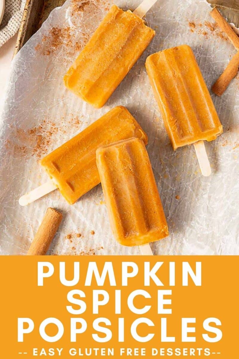 Four orange pumpkin popsicles, infused with pumpkin spice, are arranged on crinkled parchment paper with cinnamon sticks nearby. Text reads: "Pumpkin Spice Popsicles - Easy Gluten Free Desserts.