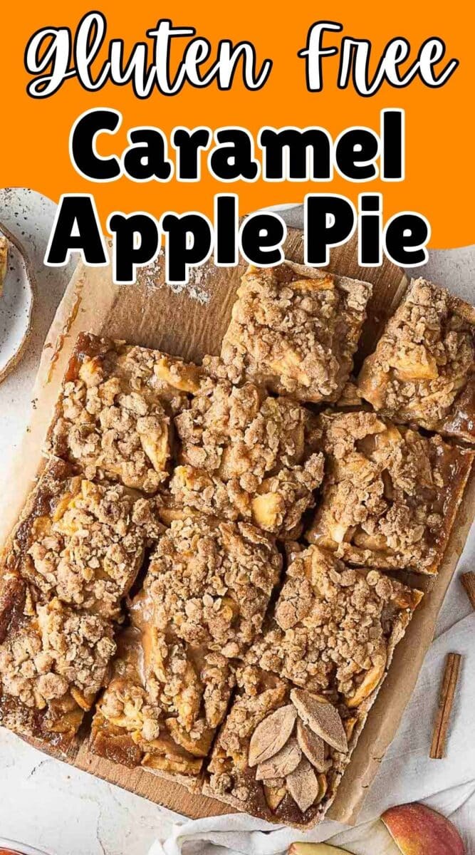 A tray of gluten free caramel apple pie bars cut into squares on parchment paper, each topped with a crumbly streusel for the perfect autumn treat.