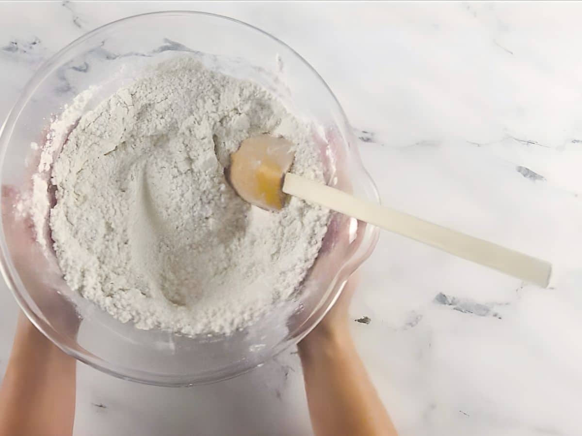 A person holding a bowl of flour.