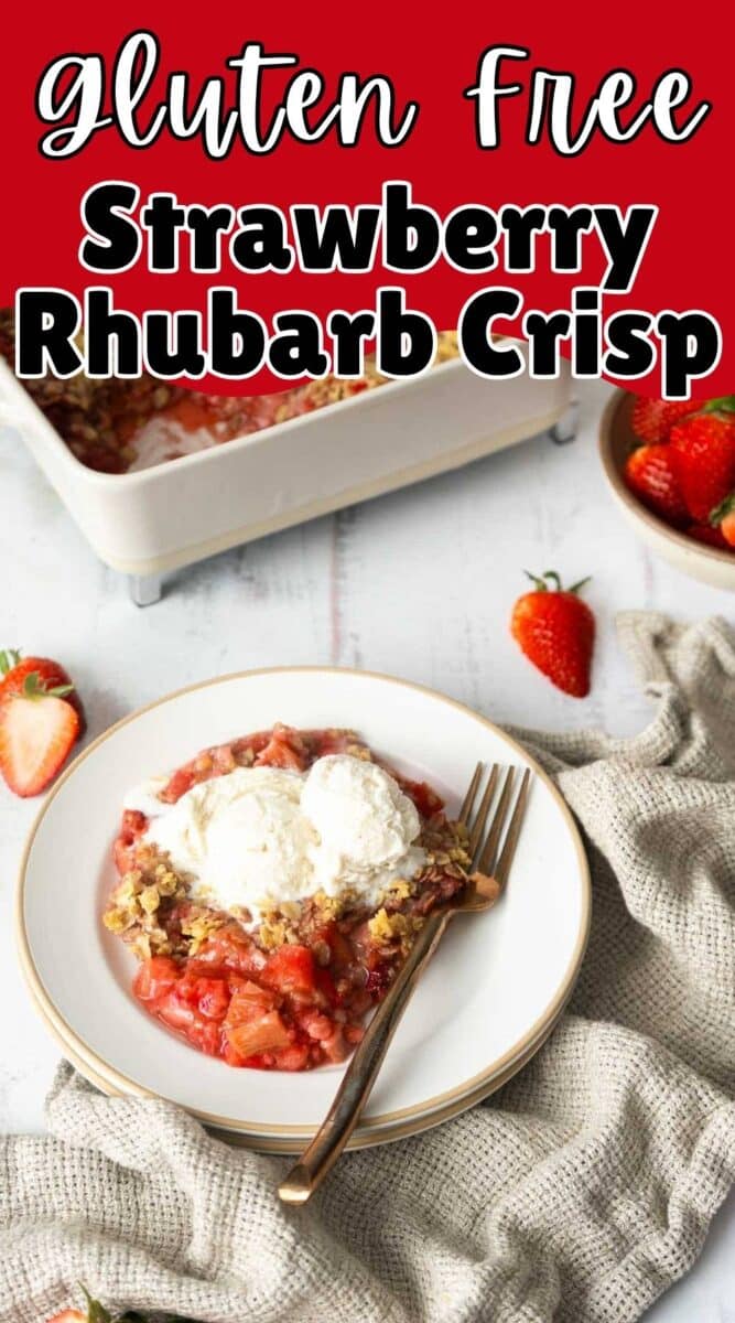 A plate of Gluten-Free Strawberry Rhubarb Crisp topped with two scoops of ice cream, served alongside fresh strawberries and a baking dish in the background.
