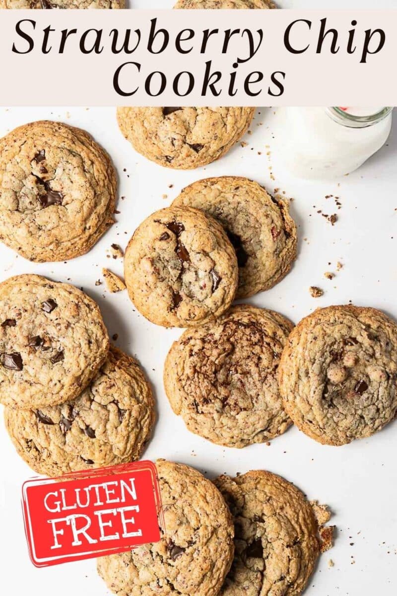 A batch of gluten free strawberry cookies is arranged on a white surface next to a bottle of milk; a label highlights their delicious, allergy-friendly appeal.