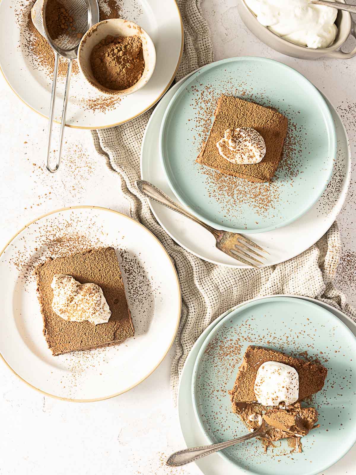 A group of plates with desserts on them, including a rich 3 ingredient chocolate cake and a tempting no bake chocolate cake.