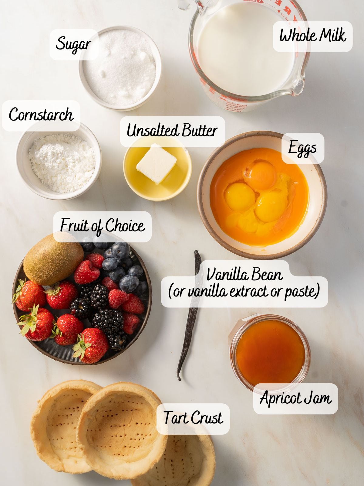 Baking ingredients on a counter: whole milk, sugar, cornstarch, unsalted butter, eggs, fruit, vanilla bean, tart crusts, and apricot jam.