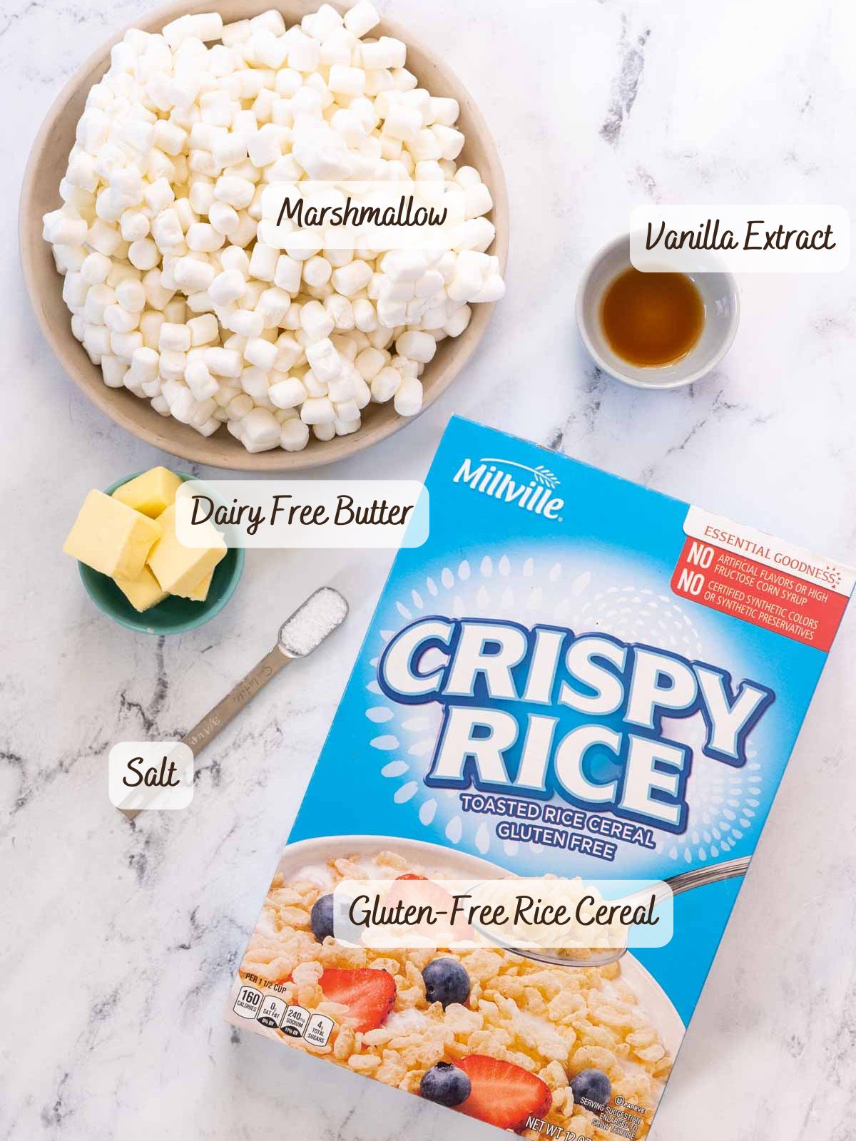 Ingredients for gluten free rice krispy treats displayed: a bowl of marshmallows, vanilla extract, dairy-free butter, a small dish of salt, and a box of gluten-free rice cereal.