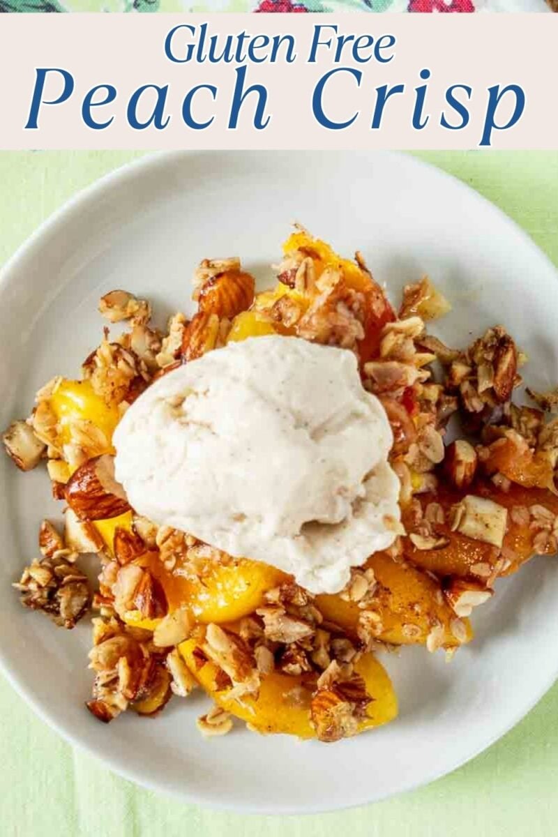 A serving of gluten-free peach crisp topped with a scoop of vanilla ice cream on a white plate. The text "Gluten Free Peach Crisp" appears at the top.