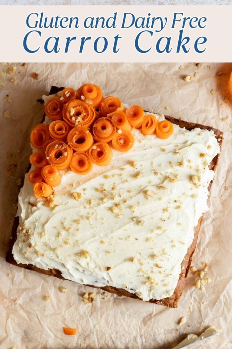 A square carrot cake with white frosting, topped with carrot curls, sits on parchment paper. Text above reads "Gluten and Dairy Free Carrot Cake.