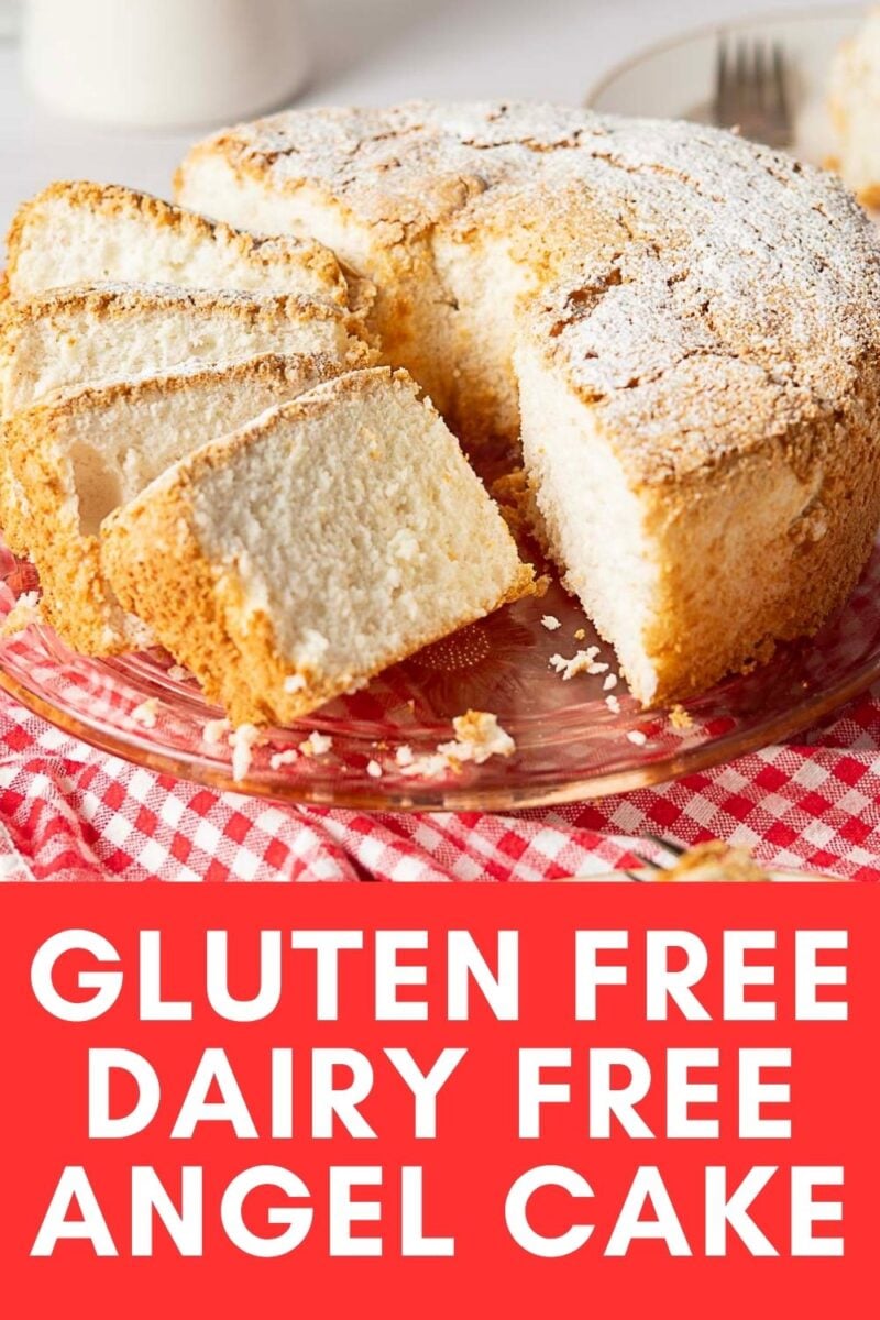 A sliced Gluten Free Angel Food Cake, dusted with powdered sugar, sits on a glass plate atop a red checkered cloth—perfect for a light, dairy-free treat.