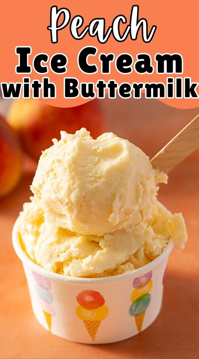 A cup of peach ice cream with buttermilk, served in a colorful paper cup with a wooden spoon, against a peach-colored background.