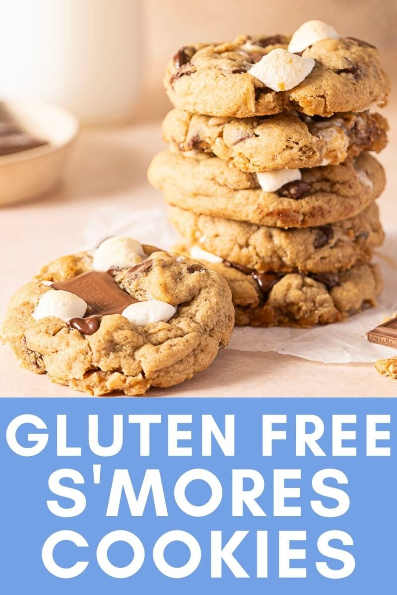 A stack of gluten free S’mores Cookies with chocolate and marshmallows sits next to a single cookie, with text reading “Gluten Free S’mores Cookies” at the bottom—perfect for anyone craving delicious Gluten Free Cookies with a classic campfire twist.
