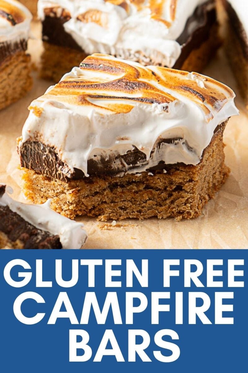 A bar dessert with a golden brown base, rich chocolate layer, and a toasted marshmallow top, reminiscent of classic S'Mores Bars. This treat is labeled "Gluten Free Campfire Bars" at the bottom, making it perfect for those who crave delicious Gluten Free S'Mores flavors.