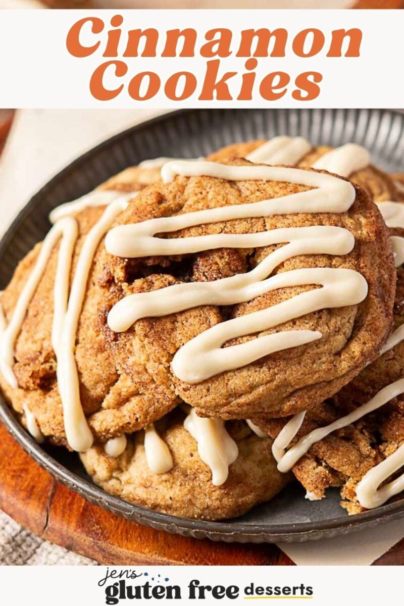 A plate of round Cinnamon Roll Cookies drizzled with white icing, stacked on a round metal tray. Text reads “Cinnamon Roll Cookies” and “gluten-free desserts.”.