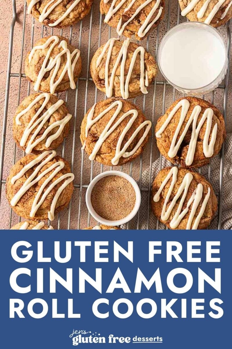 A cooling rack with freshly baked gluten-free cinnamon roll cookies drizzled with white icing, a glass of milk, and a small bowl of cinnamon sugar. Text reads: Gluten-Free Cinnamon Roll Cookies.
